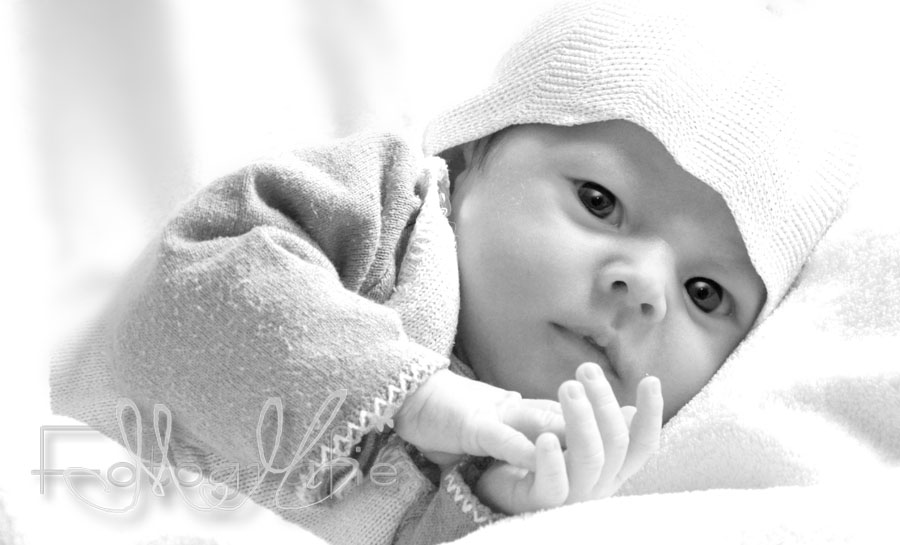 Ein kleines Baby schaut neugierig und mit ganz großen Augen in die Welt.