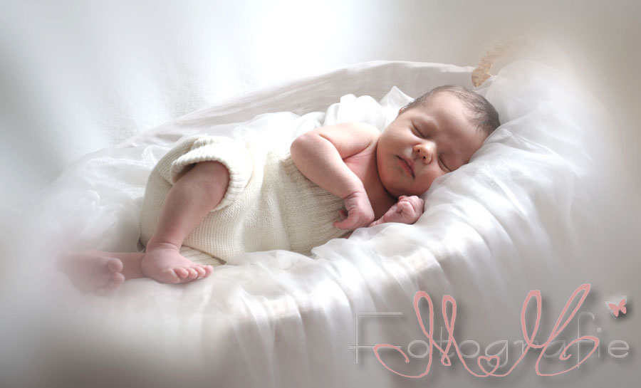 Babyfoto. Das kleine Baby liegt schlafend in einem Korb.