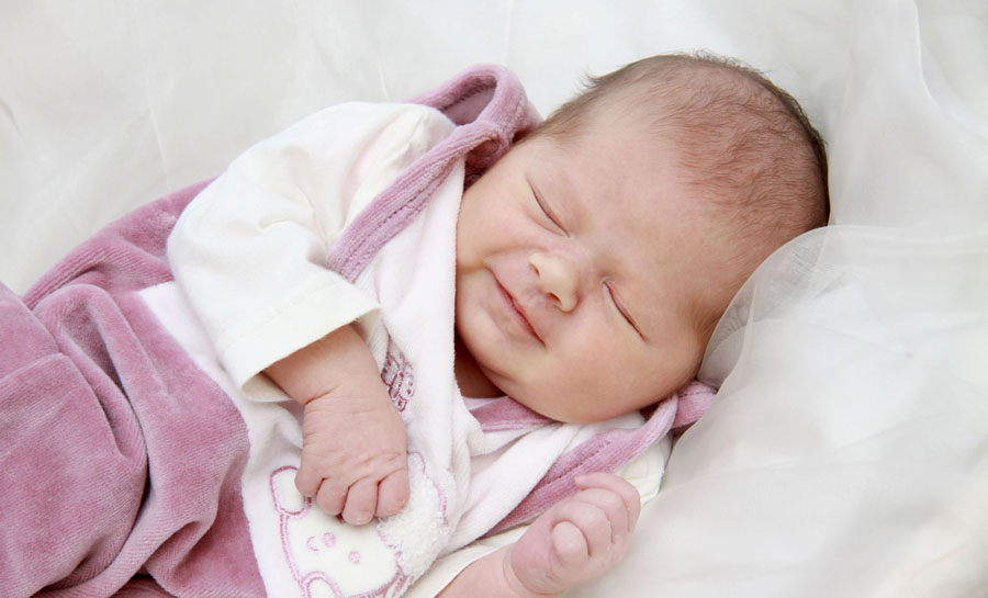 kleines Baby lächelt im Schlaf
