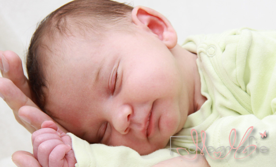 Fotografie eines kleinen Babys in Papas Hand.