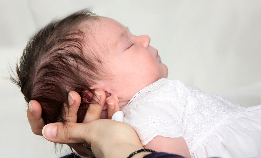 Baby mit einem weißen Kleidchen