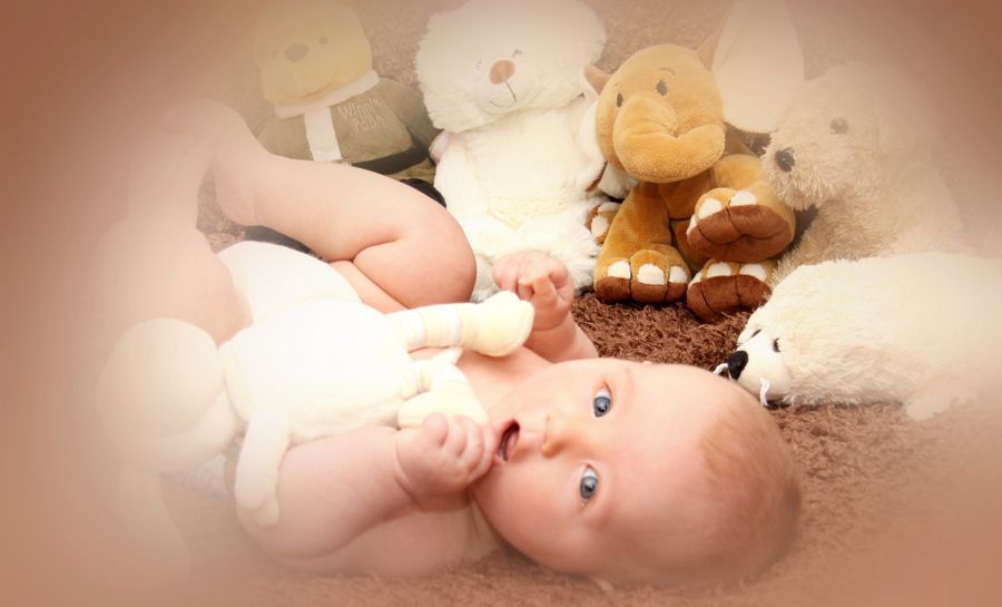 Baby, umgeben von Kuscheltieren