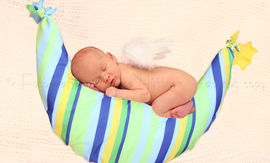 Ein süßes kleines Baby liegt träumend auf einem Mond