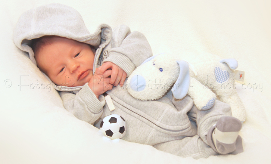 Kleines Baby mit Kuscheltier und Fußball