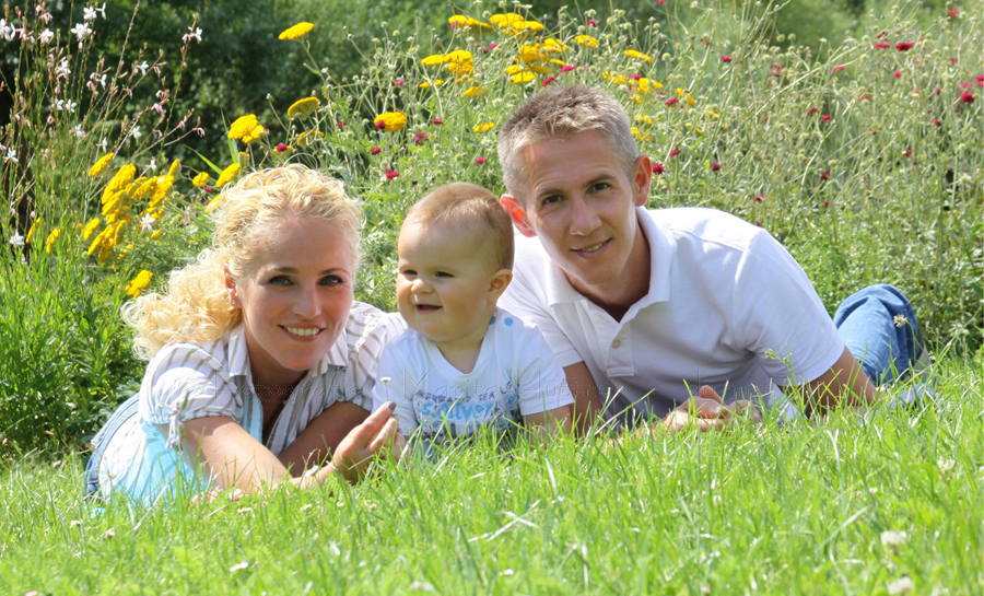 Familienfoto auf einer Wiese - Vater, Mutter, Kind