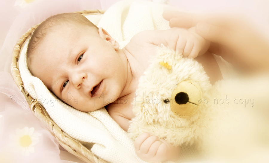 kleines Baby im Korb lachend