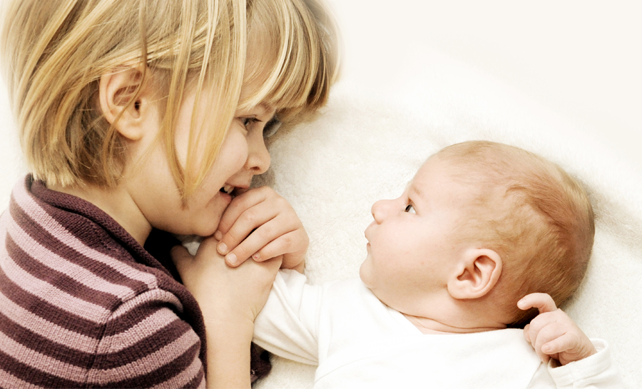 neugeborenes Baby mit seiner Schwester